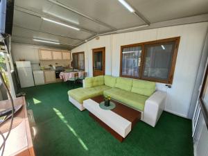 a living room with a green couch and a table at Къща за гости Зеленец in Sozopol