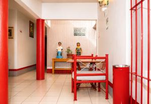 a red chair and a table in a room at Hotel Posada el Cid in Oaxaca City