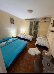 two beds in a room with blue sheets at Apartman Marković in Meljine