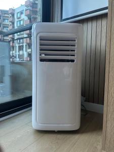 a white refrigerator sitting on a floor next to a window at Les Marcassins - Cinéma privé - Alpexpo - 5 Chambres in Échirolles