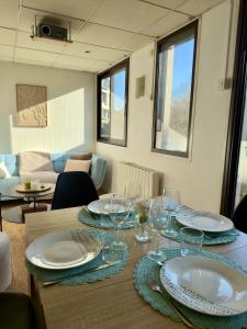 a table with plates and glasses on top of it at Les Marcassins - Cinéma privé - Alpexpo - 5 Chambres in Échirolles