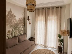 a living room with a couch and a window at Appartement Chaleureux et Cosy Proche De sortie autoroute in Mohammedia