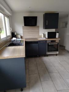 a kitchen with black cabinets and a counter top at L' Eminence in Clécy