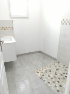 a white bathroom with a sink and a tile floor at L' Eminence in Clécy +9 photos