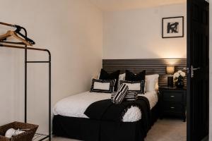a bedroom with a bed with black and white pillows at Newcastle City Centre 2BR, Near Central Train Station in Newcastle upon Tyne