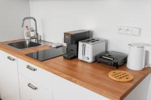 a kitchen counter with a sink and a microwave at Lipno - apartmán C404 in Frymburk