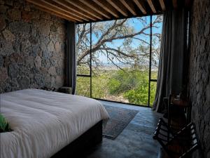 a bedroom with a bed and a large window at Casa X in San Miguel de Allende