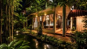 a house with a pond in front of it at Nong Thale Garden in Ban Khao Klom