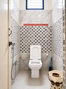 a bathroom with a white toilet and a sink at Hotel Eva Palace in Chatra