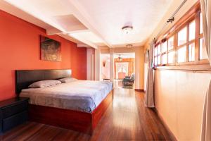 a bedroom with red walls and a bed in a room at Hotel Castillo in San José