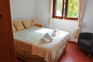 a bedroom with a bed with towels on it at Casa do Castelo - Calm & lovely 2-bedroom Apt Near the Beach in Sesimbra