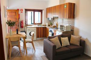 a living room with a couch and a table and a kitchen at Casa do Castelo - Calm & lovely 2-bedroom Apt Near the Beach in Sesimbra
