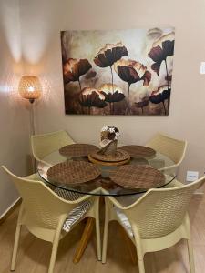 a dining room table with chairs and a painting on the wall at BeM Ipanema in Rio de Janeiro