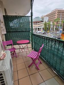 two pink chairs and a table on a balcony at SCI Severin in Pointe-à-Pitre