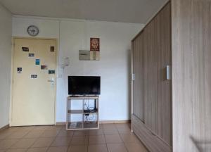 a hallway with a tv and a door and a tv stand at SCI Severin in Pointe-à-Pitre