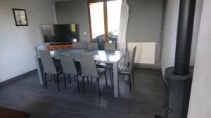 a dining room with a table and chairs and a television at La Varendiere in Saint-Lambert