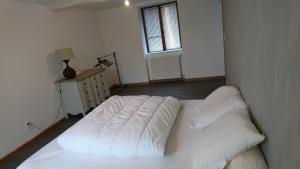 a white bed in a room with a window at La Varendiere in Saint-Lambert