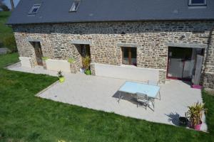 a patio with a table and chairs in front of a building at La Varendiere in Saint-Lambert