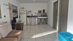 a kitchen with a couch and a table in a room at Casa Pitanga Quarto in Barra do Garças