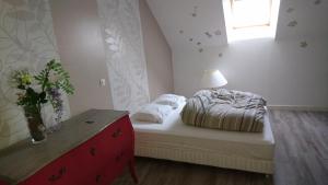 a bedroom with a bed and a dresser and a window at La Varendiere in Saint-Lambert +2 photos