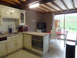 a kitchen with yellow cabinets and a dining room with a table at La Varendiere in Saint-Lambert