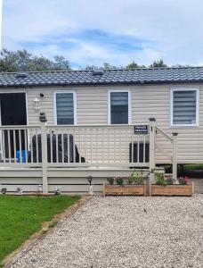 a mobile home with a porch and a fence at MLR at Craig Tara Bay View in Ayr