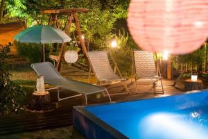 a group of chairs and an umbrella next to a pool at Milyang Sweety Pension in Miryang