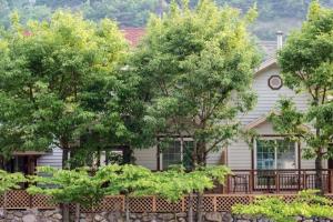 a house with trees in front of it at Milyang Sweety Pension in Miryang