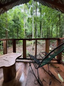 a green chair sitting on a porch with a table at Entire Jungle Chalet Playa Ganadito in Drake +17 photos