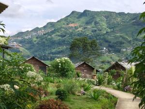 a group of huts with a mountain in the background at De Mont Retreat Sapa in Sapa +85 photos