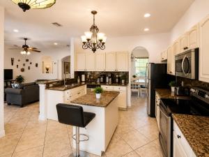 a kitchen with white cabinets and a black refrigerator at The Oasis, Miami Lakes in Miami Lakes
