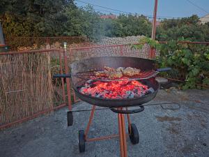 a grill with chicken and other food on it at Casa Maja in Karlobag