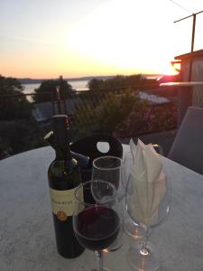 a bottle of wine and two glasses on a table at Casa Maja in Karlobag