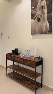 a wooden table with a horse painting on the wall at Pearl sea in Al Jubail