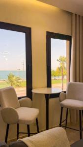 a room with two chairs and a table with a view of the ocean at Pearl sea in Al Jubail