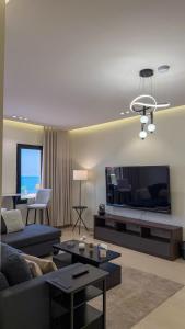 a living room with a couch and a flat screen tv at Pearl sea in Al Jubail