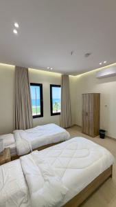 a large bedroom with two beds and two windows at Pearl sea in Al Jubail