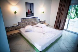 a bed with white sheets and pillows in a room at The Village Resort By Acquaviva Gammarth in Gammarth