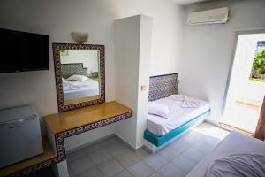 a hotel room with a mirror and a bed at The Village Resort By Acquaviva Gammarth in Gammarth