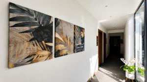 a hallway with four panels of art on the wall at La Veranda Pyramids View Hotel in Cairo