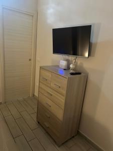 a dresser with a flat screen tv on top of it at Solforia Holiday House in Pozzuoli