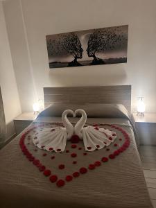 a bed with a heart made out of roses at Solforia Holiday House in Pozzuoli