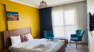 a bedroom with a bed and two blue chairs at Ay suit in Esenyurt