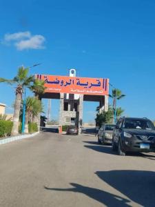 a street with cars parked on the side of the road at الساحل الشمالي قرية الروضة in El Alamein