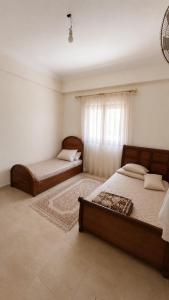 a bedroom with two beds and a window at الساحل الشمالي قرية الروضة in El Alamein