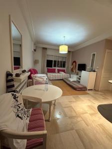 a living room with a table and a couch at Cozy One Bedroom Apartment in Nabeul