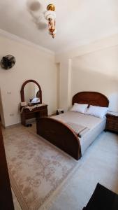 a bedroom with a large bed and a mirror at الساحل الشمالي قرية الروضة in El Alamein