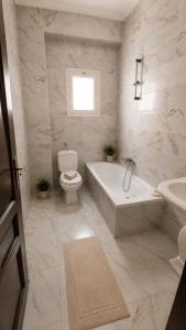 a bathroom with a tub and a toilet and a sink at الساحل الشمالي قرية الروضة in El Alamein