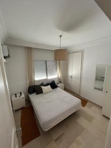 a bedroom with a white bed and a window at Cozy One Bedroom Apartment in Nabeul