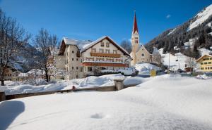 a town covered in snow with a church at Gasthof Bären in Holzgau